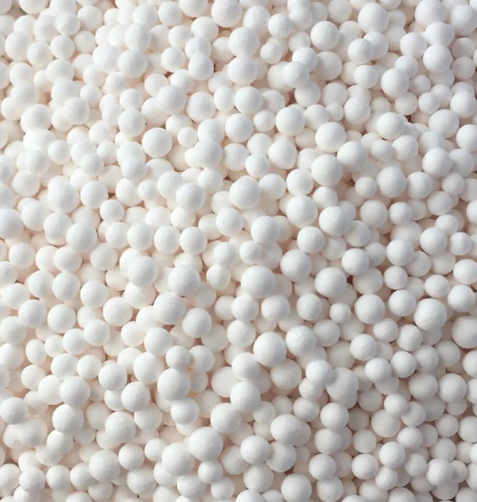 Close up photo of white, piled activated alumina desiccant beads.